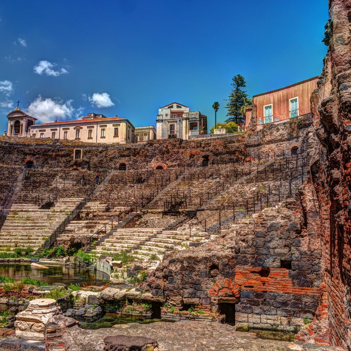 The ancient Roman Theatre of Catania, with its lava-stone terraces and historic urban backdrop.