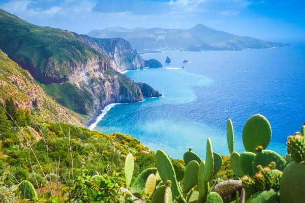 La costa frastagliata di Lipari, con acque turchesi, vegetazione lussureggiante e paesaggi iconici delle Eolie.