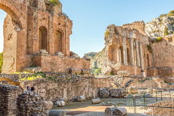 Interior view of the Ancient Theatre of Taormina, featuring its iconic brick arches and dramatic historic ruins.